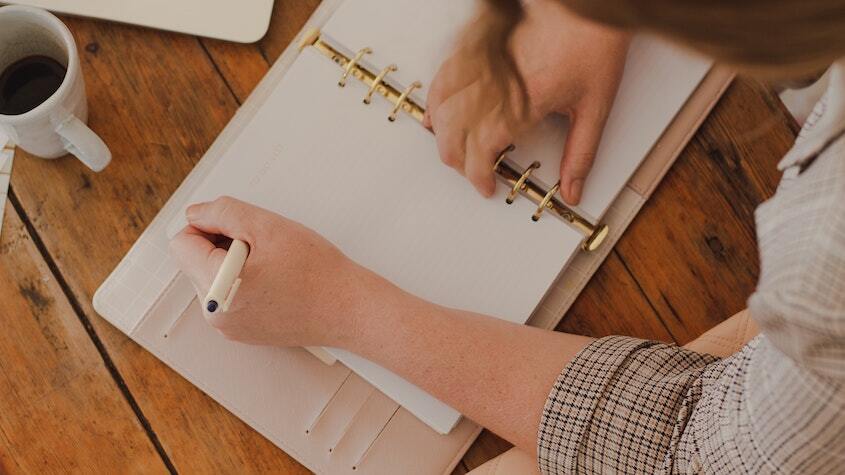 A person writing on a notebook