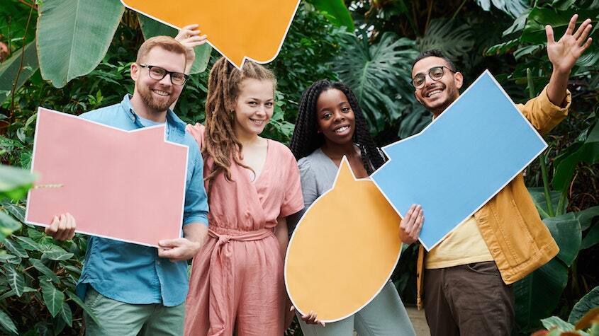 A group of people holding cartboard chat bubbles