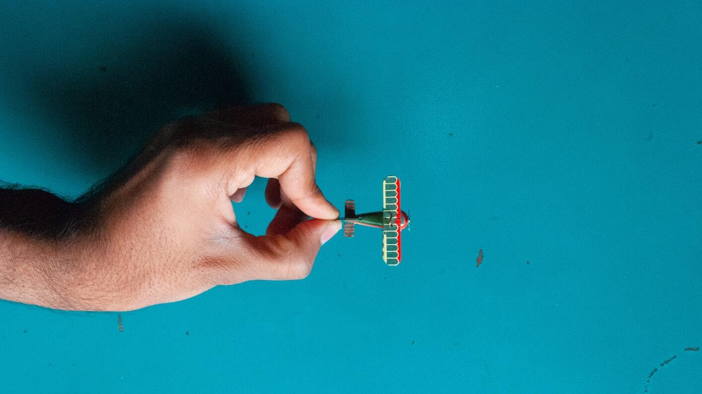 A hand holding a small toy plane